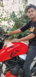 Young man riding a red motorcycle outdoors.