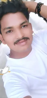 Young man in white shirt and bracelets outdoors.