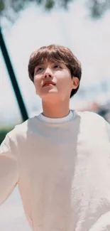 Young man gazing up under a clear blue sky.