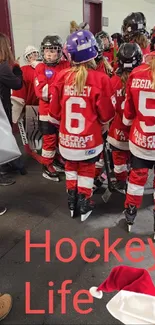 Youth hockey team huddled in red jerseys with helmets, ready for the game.