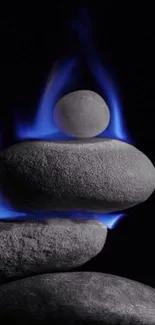 Stacked stones with blue flames on black background.