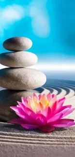 Mobile wallpaper with zen stones and a pink lotus flower on sand.