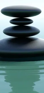 Stack of zen stones with reflection on calm water wallpaper.