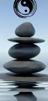 Zen rock stack with yin yang symbol in tranquil setting.