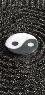 Yin yang symbol on textured sand background.